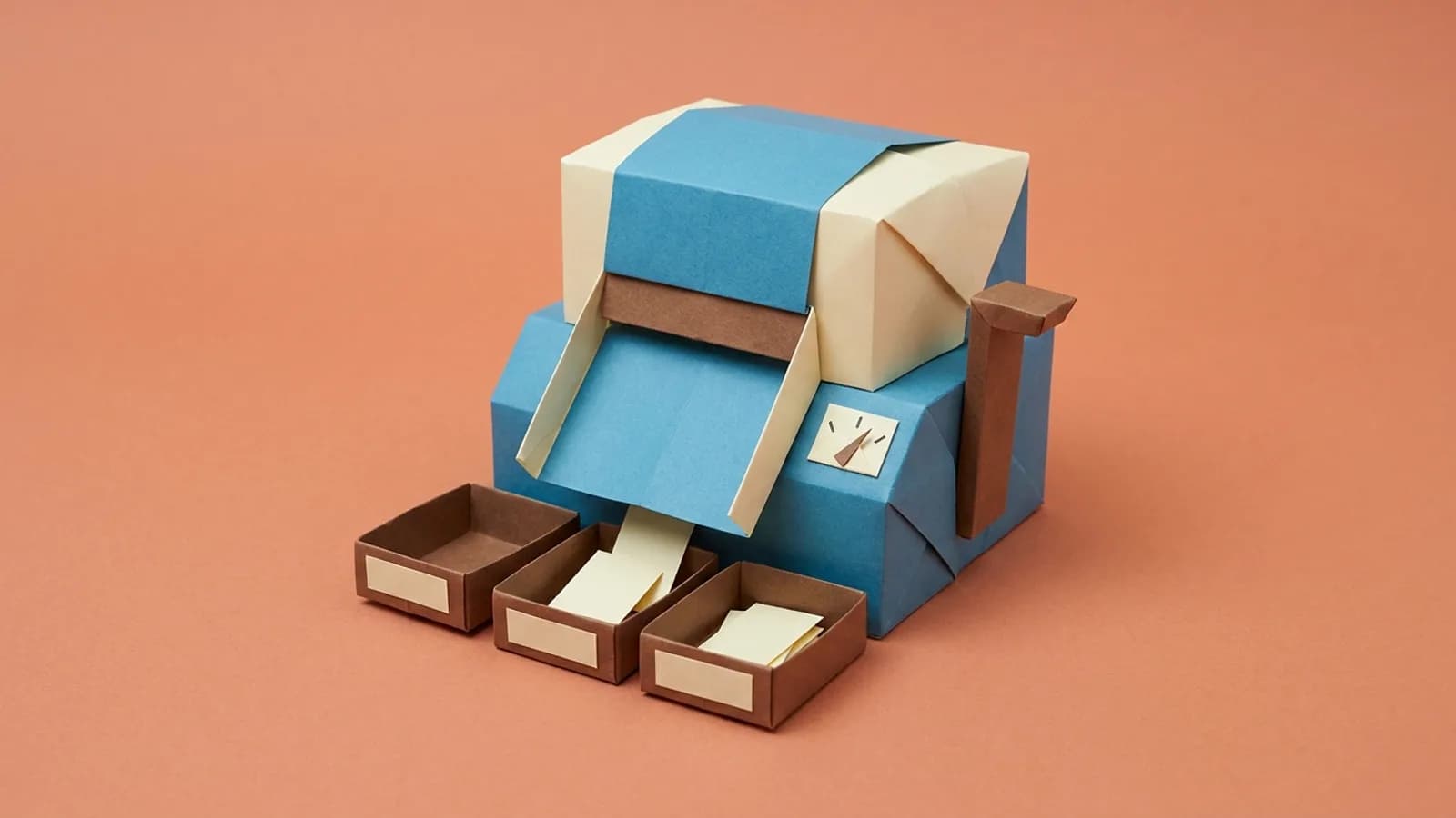 Paper model of a sorting machine with a dial, dropping tickets into 3 labelled trays in front of it