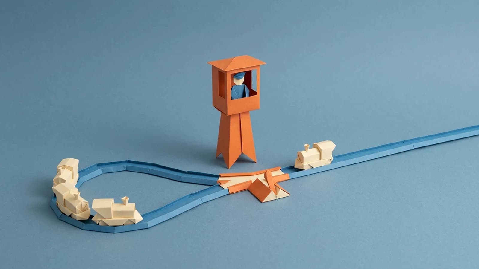 Paper signal tower whose operator switches toy trains between a short loop and a long line
